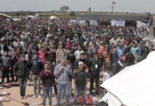 Protesters pray in front of their tents during a demonstration along the Gaza Strip border with Israel, March 30, 2018. AP/Adel Hana