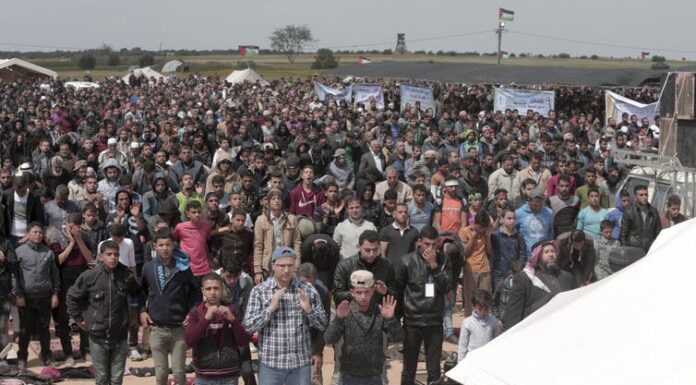 Protesters pray in front of their tents during a demonstration along the Gaza Strip border with Israel, March 30, 2018. AP/Adel Hana