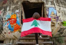 Pour toutes ces raisons … j’irai cracher sur vos tombes ! Une fille arborant le drapeau libanais à l'entrée de l'Oeuf, structure en béton du Centre ville de Beyrouth. Photographie circulant sur les réseaux sociaux. Crédit Photo: DR (droit réservé)