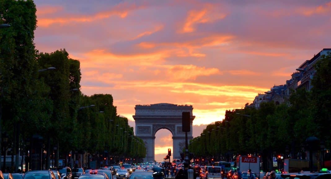 crowded street with cars along arc de triomphe