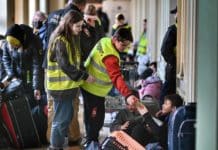 Un volontaire polonais aide un réfugié à la gare de Przemyśl.