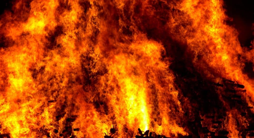 flare of fire on wood with black smokes