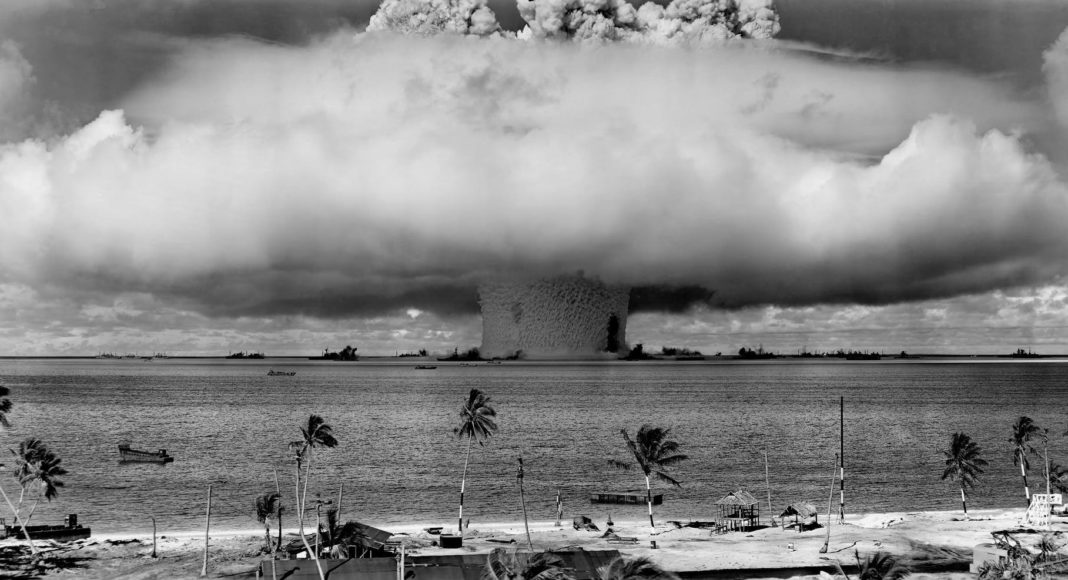 grayscale photo of explosion on the beach