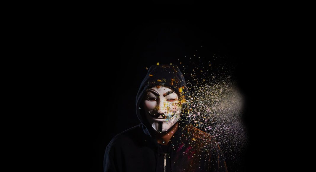 person wearing black hoodie and mask