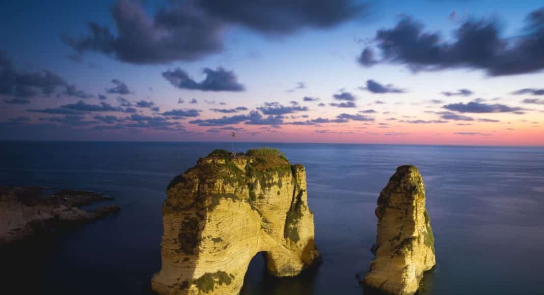 brown rock formation on the sea