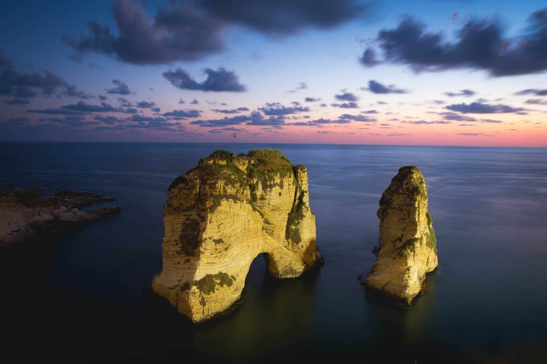 brown rock formation on the sea