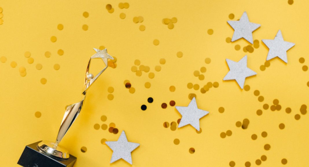 golden statuette and stars on yellow background