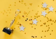 golden statuette and stars on yellow background
