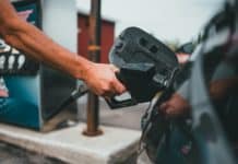 person putting gasoline on a vehicle