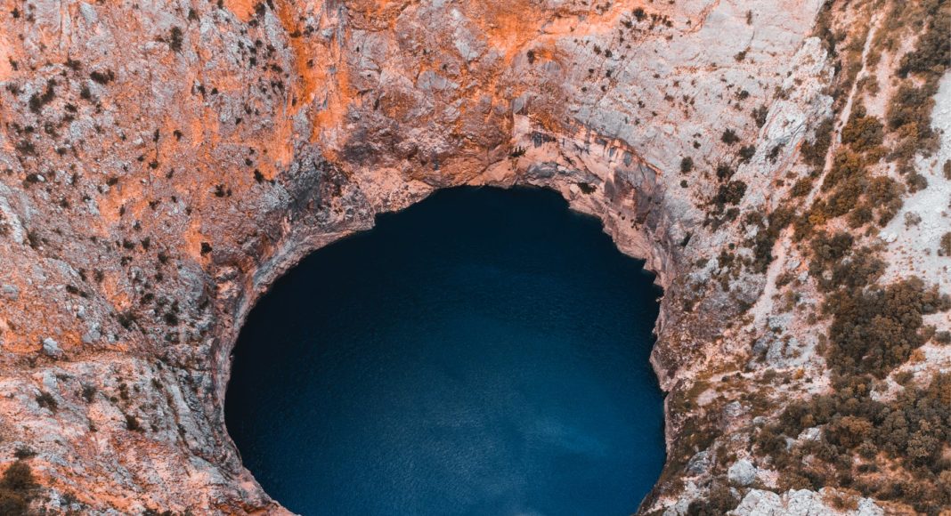 close up photography of hole and body of water