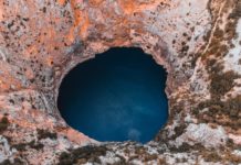 close up photography of hole and body of water