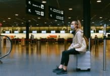 woman sitting on luggage