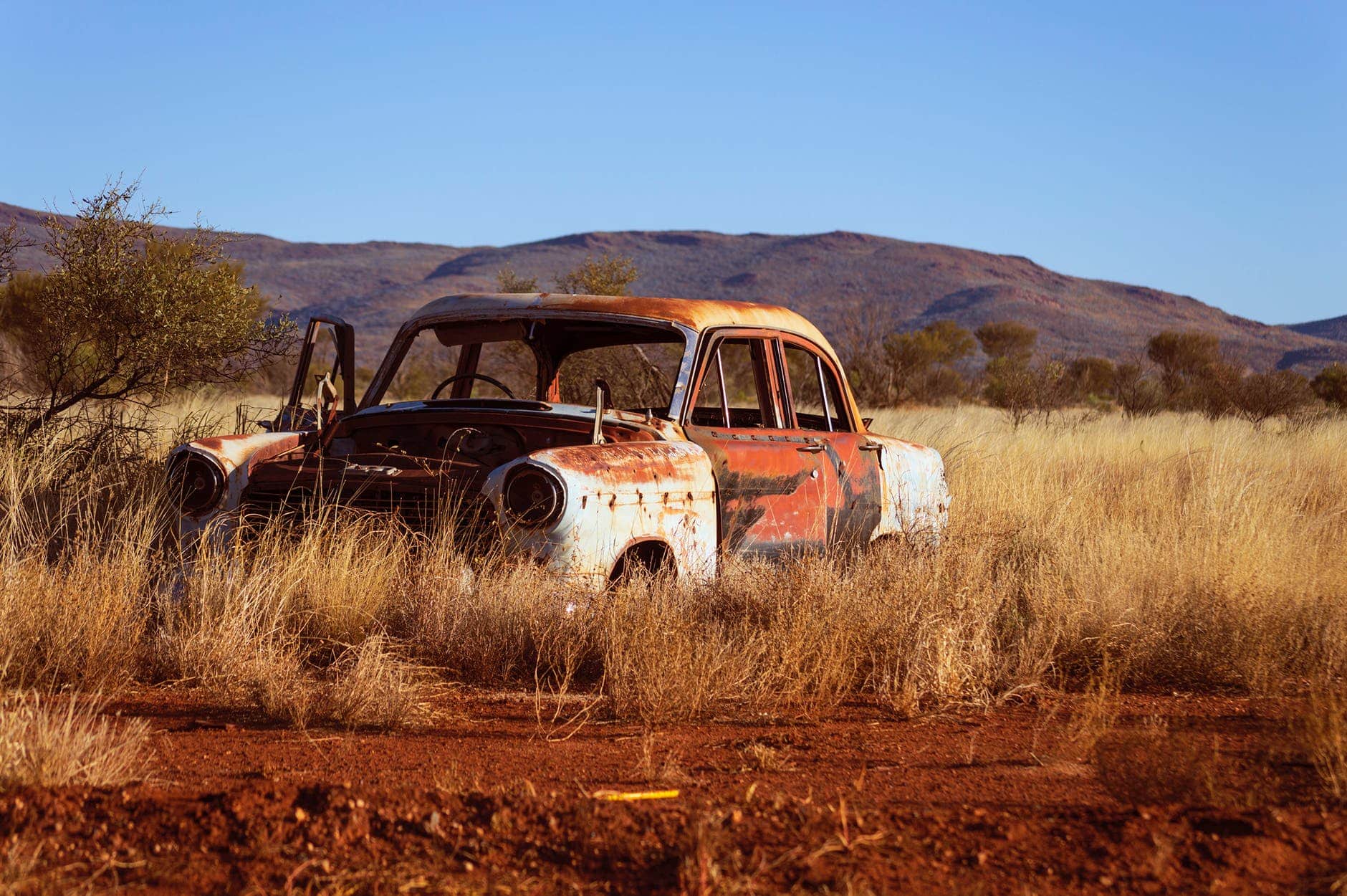 Le prix des carburants révisé à la hausse photo of corroded vintage white and red sedan on brown grass