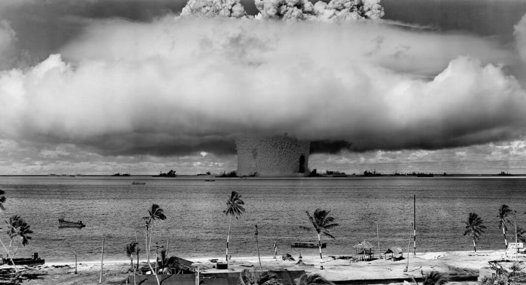 grayscale photo of explosion on the beach