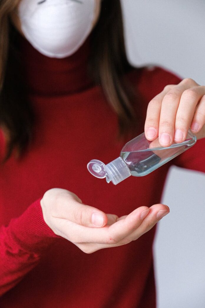 woman applying hand sanitizer
