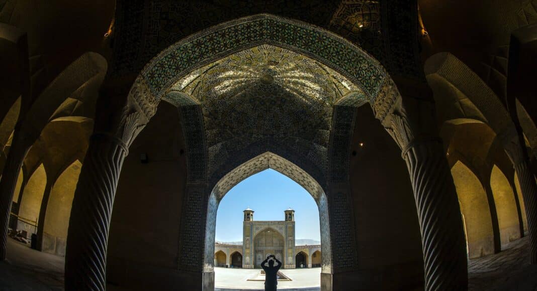 fisheye shot of a person inside a building with columns and ornate ceiling