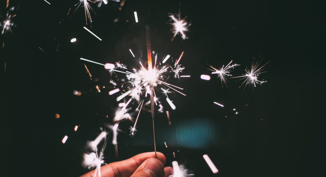 person holding firecracker at night