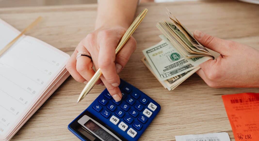 woman calculating money and receipts using a calculator