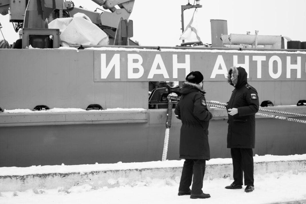 black and white photo of russsoldiers talking in front of warship