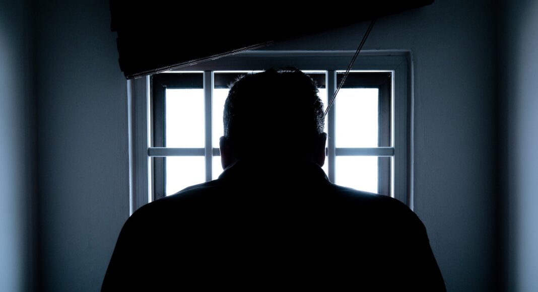rear view of a silhouette man in window