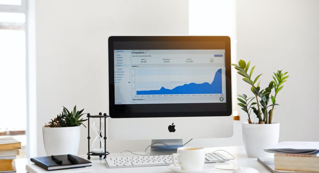 silver imac displaying line graph placed on desk