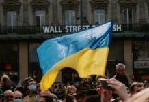 blue and yellow ukrainian flag waving above crowd of people