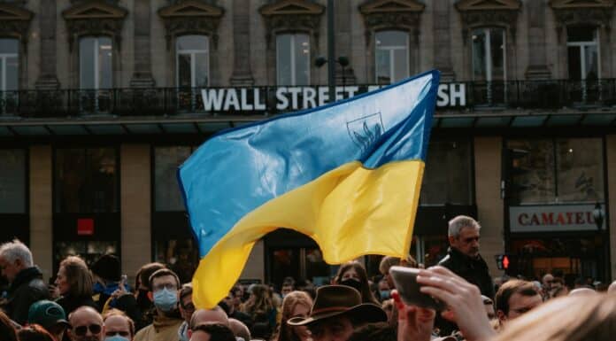 blue and yellow ukrainian flag waving above crowd of people