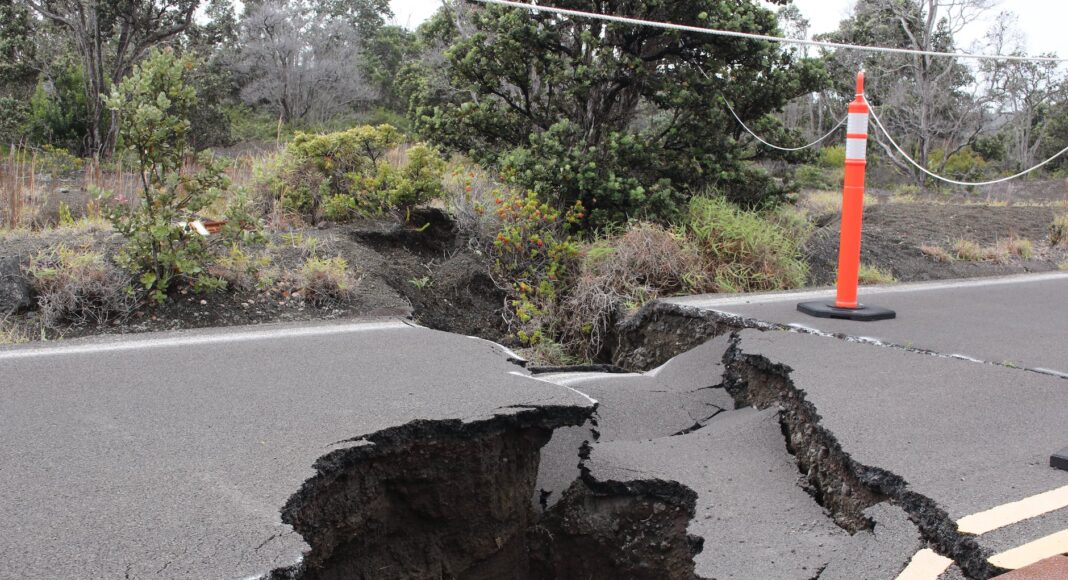orange and white traffic pole on cracked gray asphalt road