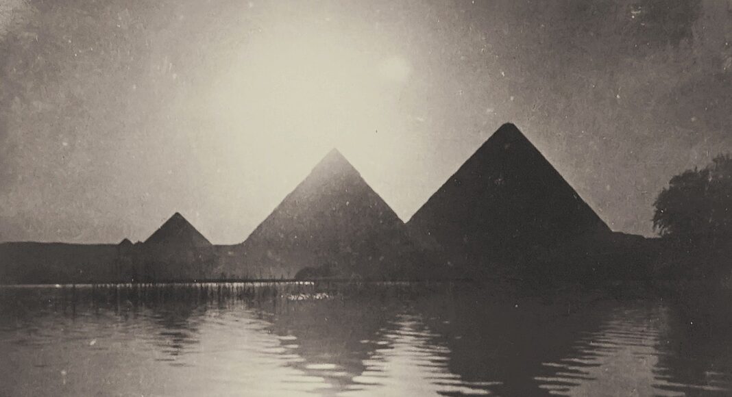 silhouette of pyramids near body of water