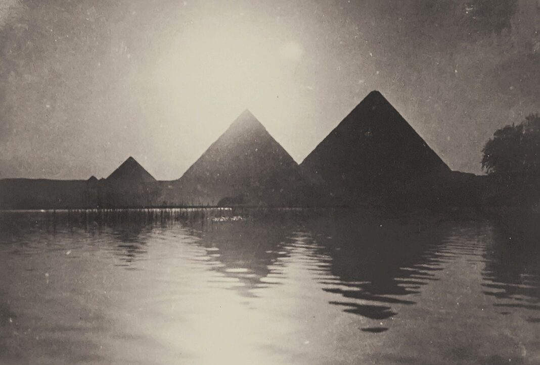 silhouette of pyramids near body of water