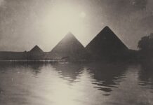 silhouette of pyramids near body of water