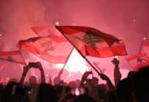 a crowd gathered in a concert waving flags