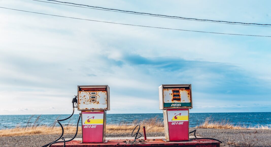 white and pink gasoline station near ocean