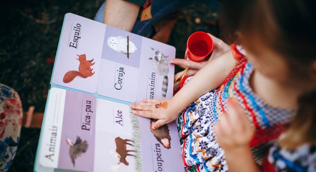 child reading book with mother in garden