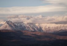 snow covered mountains under the cloudy sky