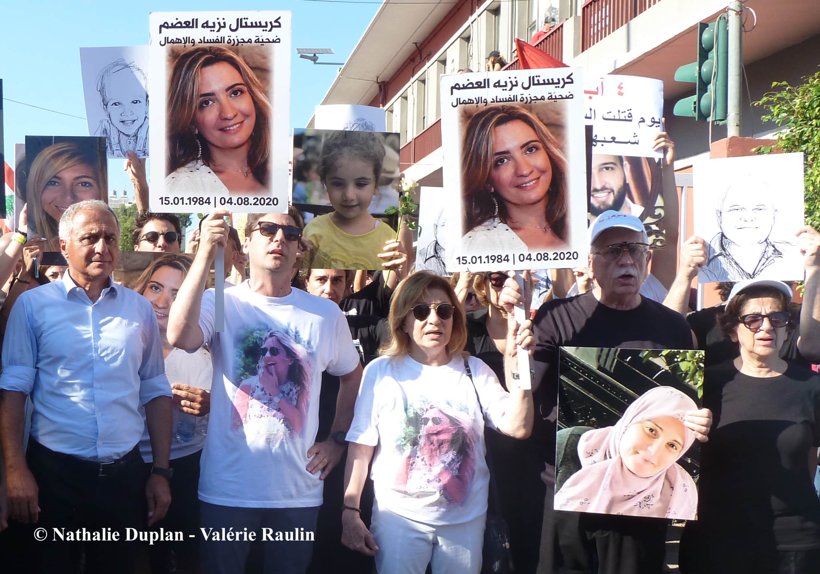 « Chaque jour est un nouveau 4 août ! » À gauche, le Dr Fouad Abou Nader venu soutenir la famille de Christelle Adem. À droite, désireux de briser les barrières communautaires, Fady Noun brandit le portrait d’une femme musulmane qu’il ne connaît pas mais dont aucun proche ne pouvait être présent. © Nathalie Duplan - Valérie Raulin