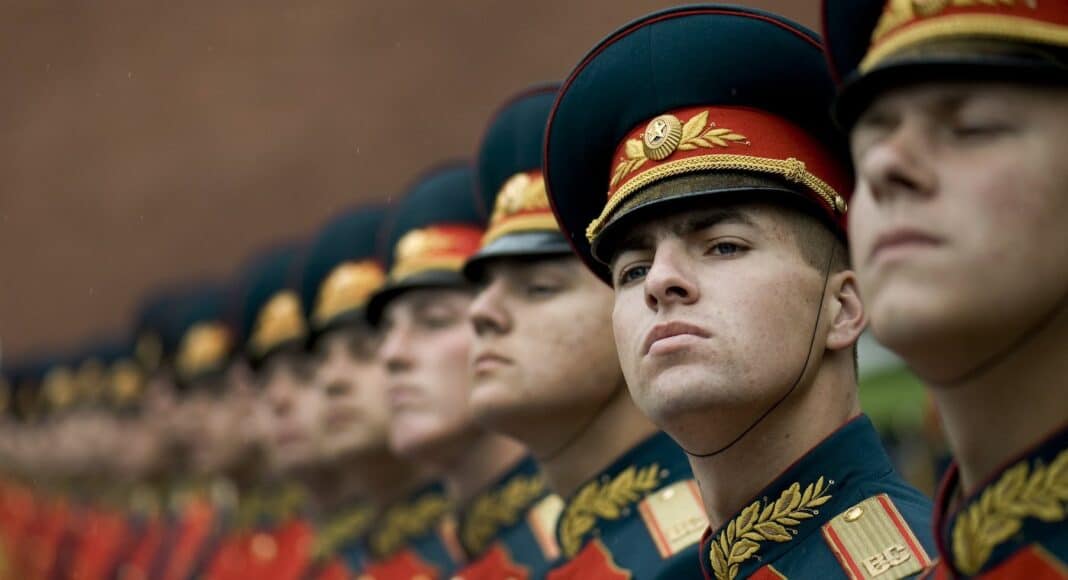 men in black and red cade hats and military uniform