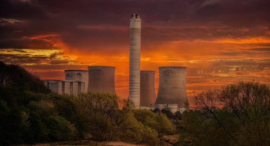 white nuclear plant silo under orange sky at sunset