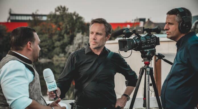 man holding microphone while talking to another man