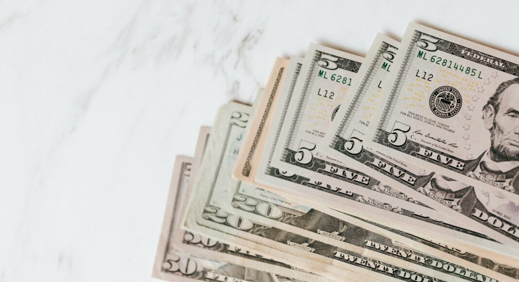 different dollar bills on marble surface