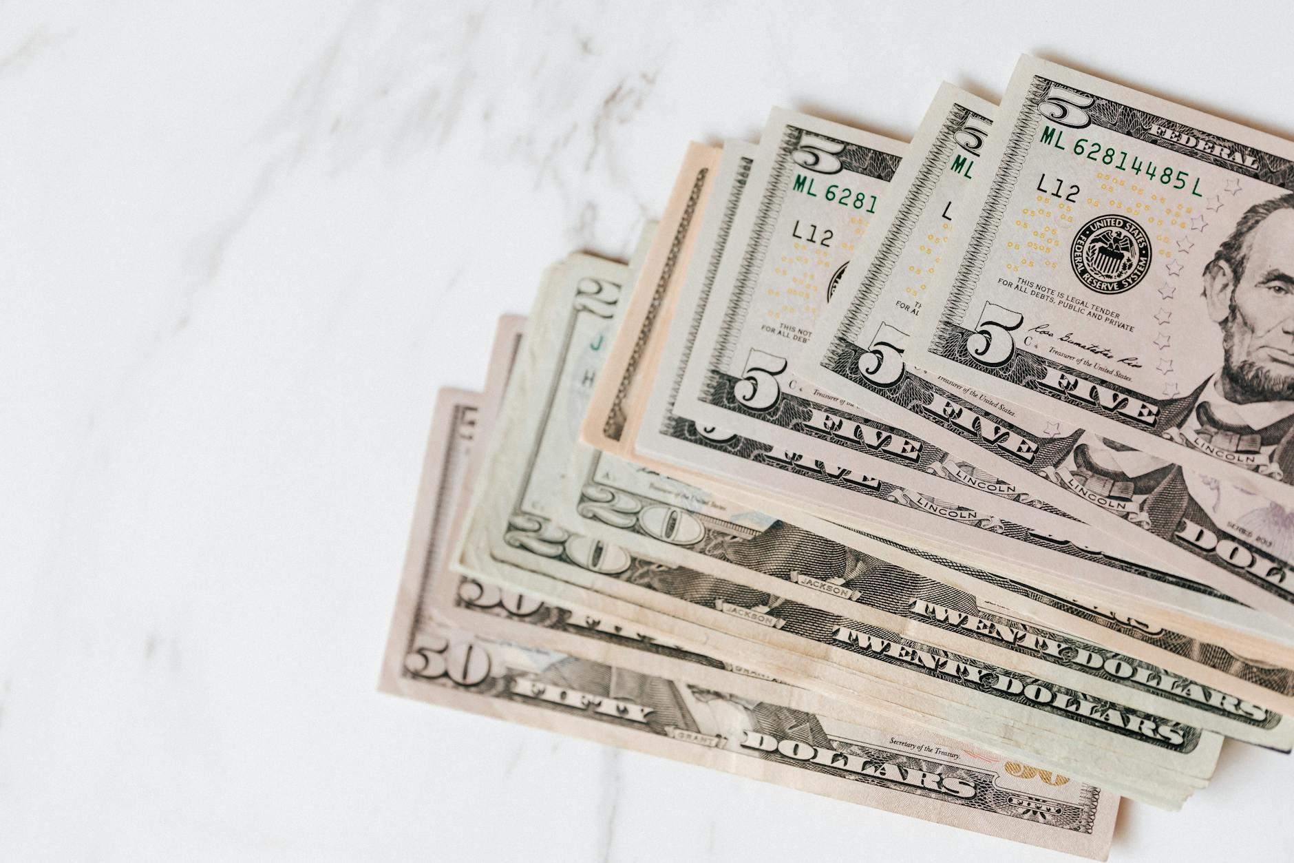 different dollar bills on marble surface