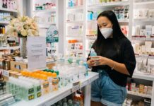woman with face mask holding an alcohol bottle