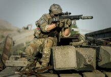 soldier near concrete pillars holding semi automatic gun with scope