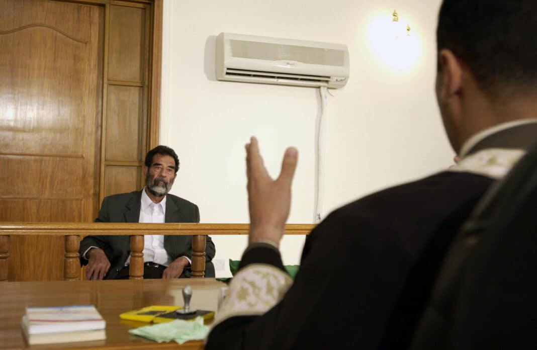 credit: Cullen/USAF/DOD. Former and deposed President of Iraq, Saddam Hussein, sits before an Iraqi judge at a courthouse in Baghdad, Iraq, where he has his initial interview to inform him of what he is being investigated for and his legal rights read to him.