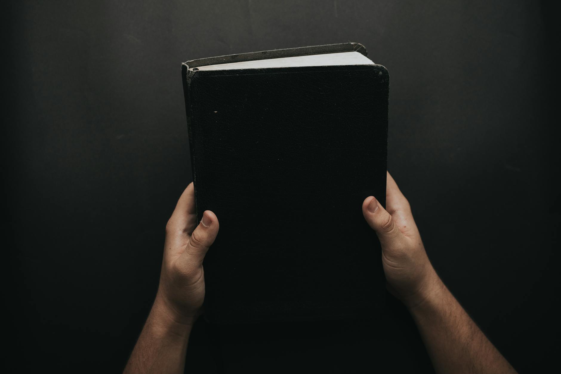 Les États Théocratiques et la Guerre : Un Cercle Vicieux de Légitimité et de Conflits Permanents person holding black cover bible