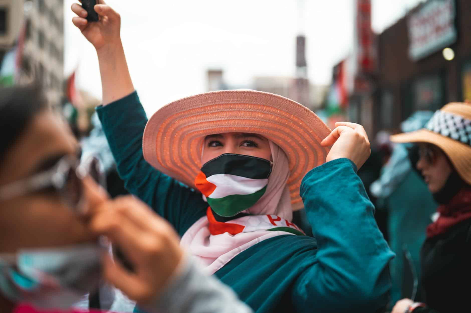 La terre Palestine irriguée avec le sang des enfants a person with a brown hat wearing palestine flag mask