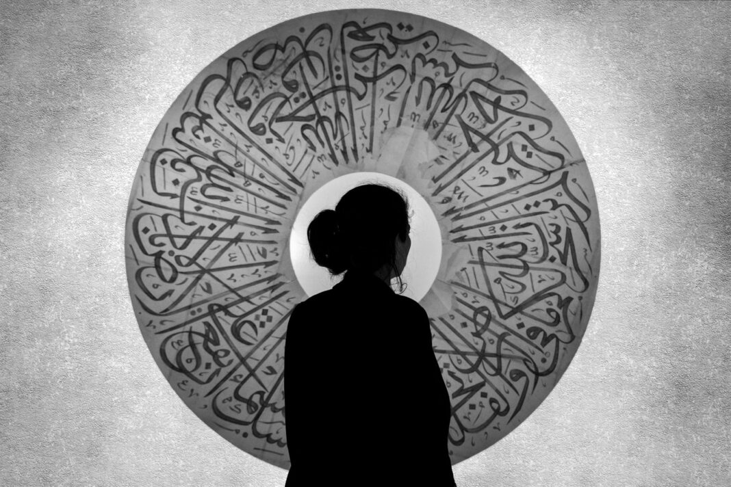 silhouette of a woman against a round arabic ornament