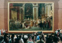 people taking photos of the painting hanging on the wall