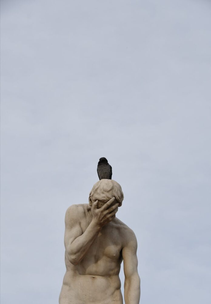bird on the sculpture of a distraught cain in paris tuileries garden
