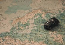 black toy car on world map paper